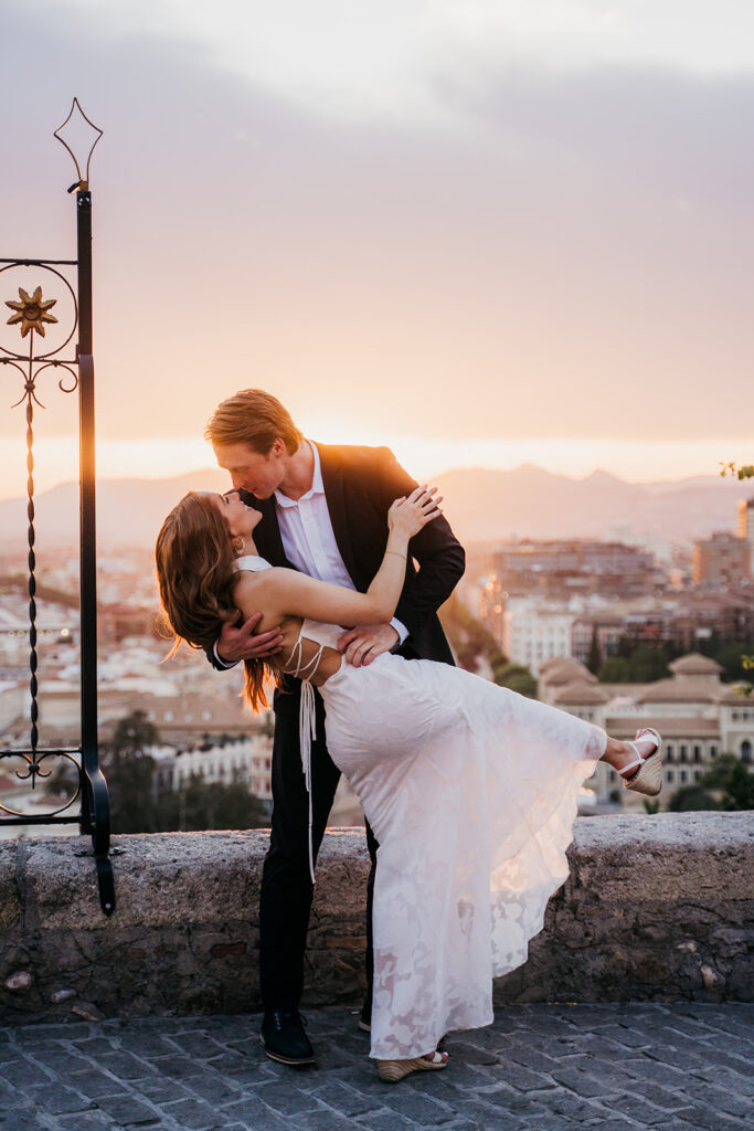 Newly engaged couple at sunset over Granada after a surprise proposal